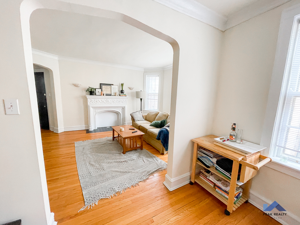 a living room with a couch and a table and a mirror